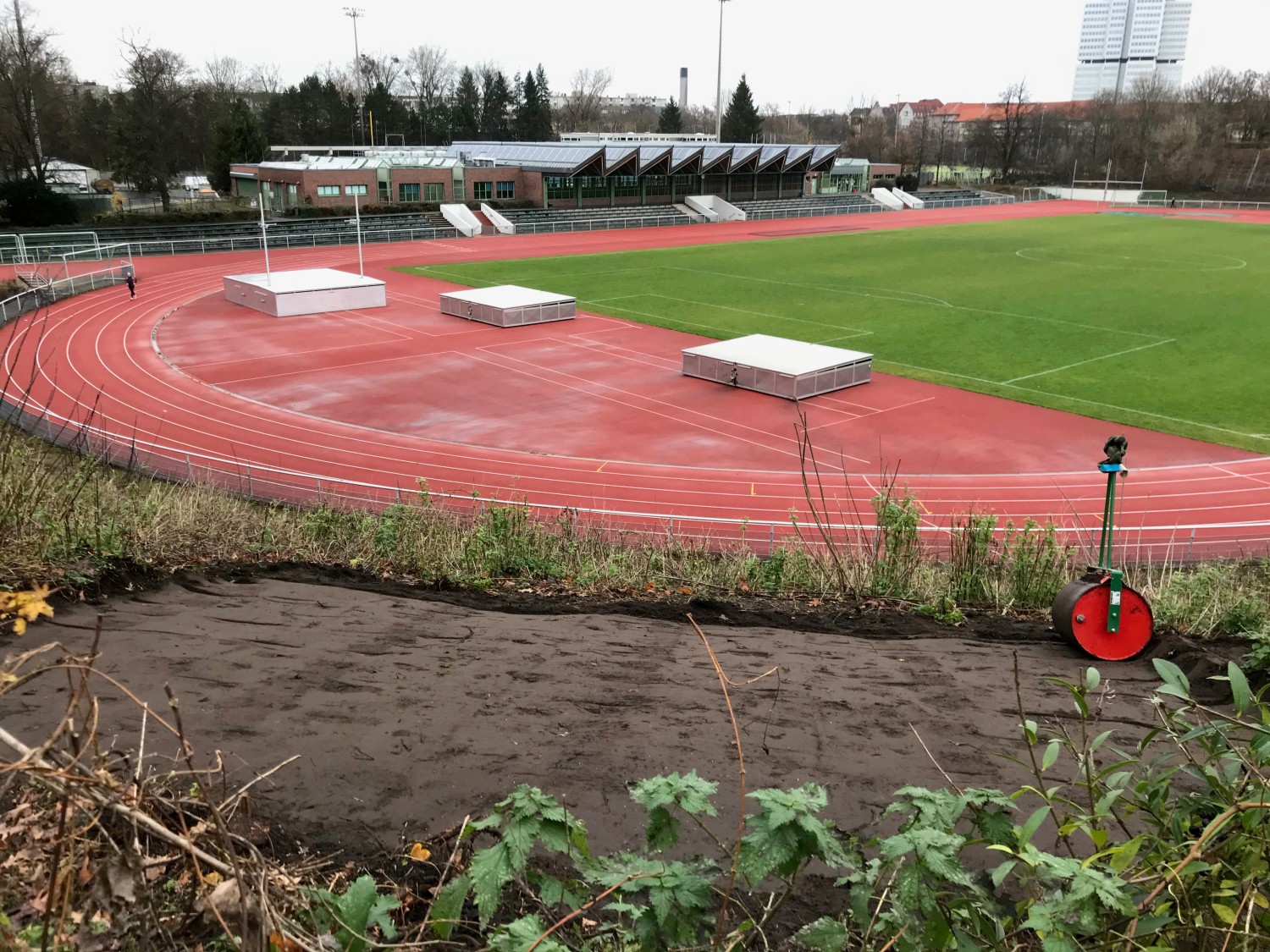 Frisch gewalzte Ansaatfläche auf der Böschung mit Walze, im Hintergrund ist der südliche Teil des Stadion Wilmersdorf zu sehen.