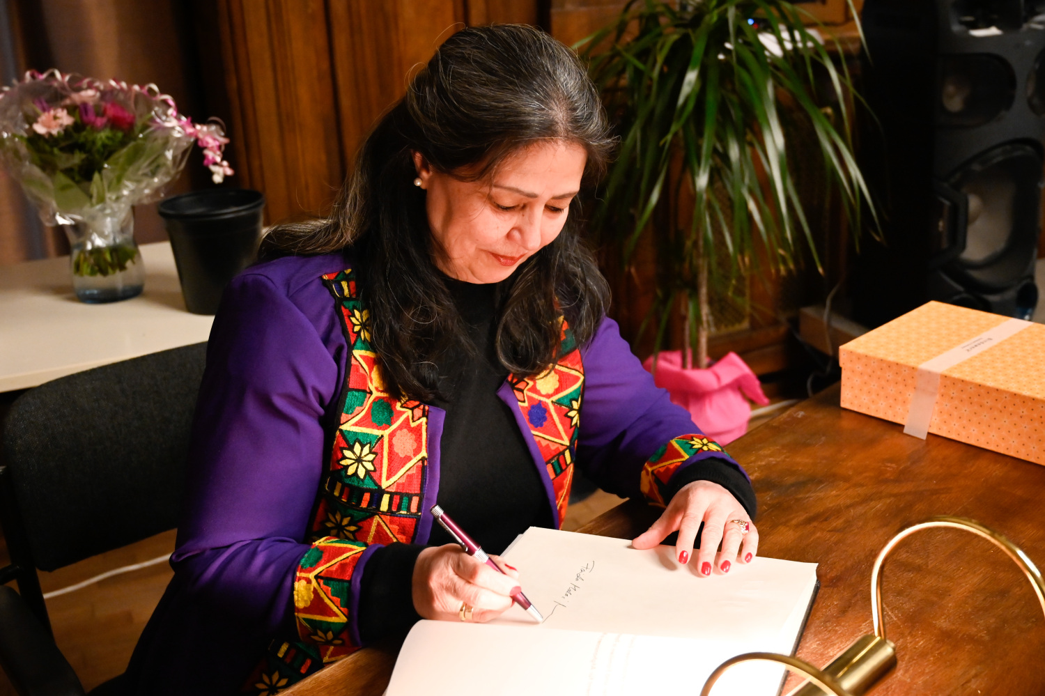 Preisträgerin Malalai Murr trägt sich in das Goldene Buch des Bezirks Pankow ein.
