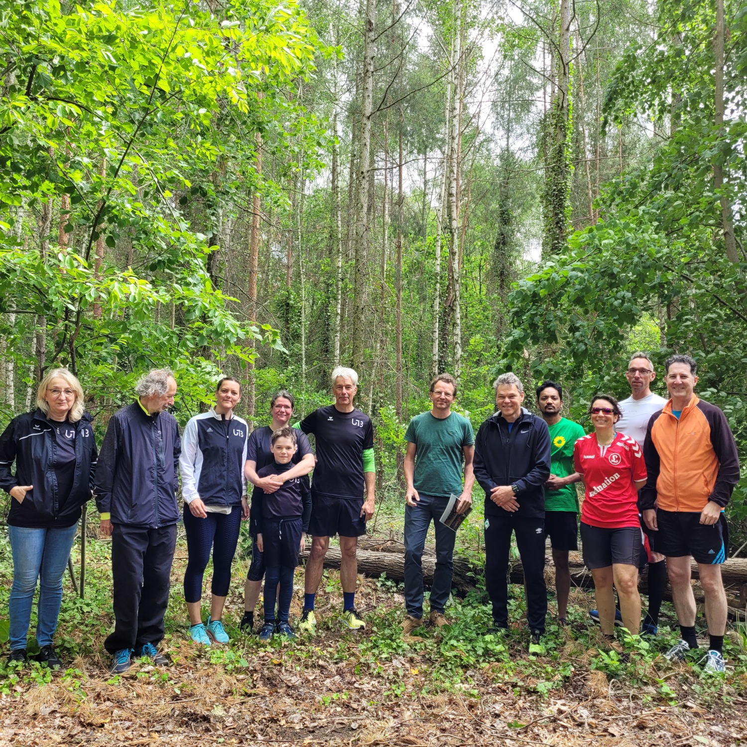 Eine Gruppe von zehn Menschen steht in einem Wald