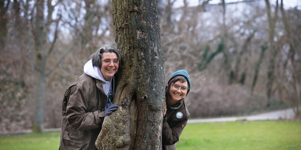 Die Stadtnaturrangerinnen stehen an einem Baum im Volkspark