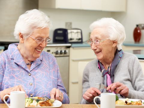 Senior women enjoying meal together at home