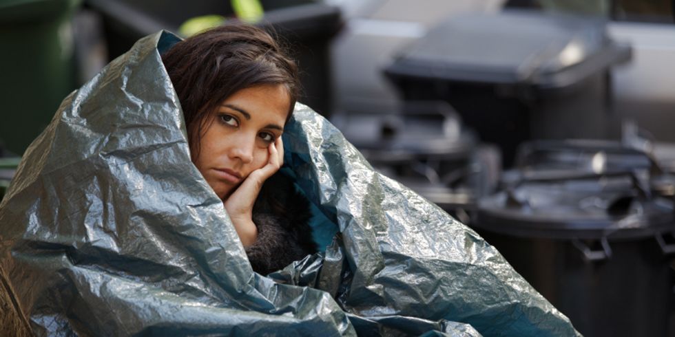Obdachlose junge Frau umwickelt mit Plastikplanen bei kaltem Wetter