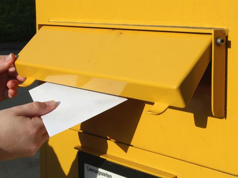 Brief wird in Briefkasten eingeworfen