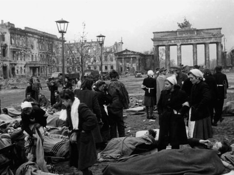 Verwundete Wehrmachtsoldaten, die in einem Frontlazarett im Hotel Adlon untergebracht waren, warten am 3. Mai 1945 vor dem Brandenburger Tor auf ihren Weitertransport
