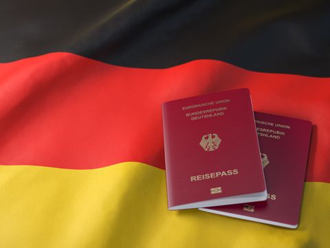 Zwei deutsche Reisepässe liegen auf der deutschen Flagge mit den Farben schwarz-rot-gold