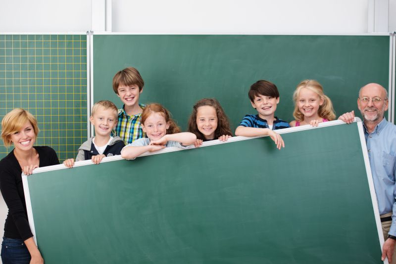 Lehrer mit Kinder vor Tafel
