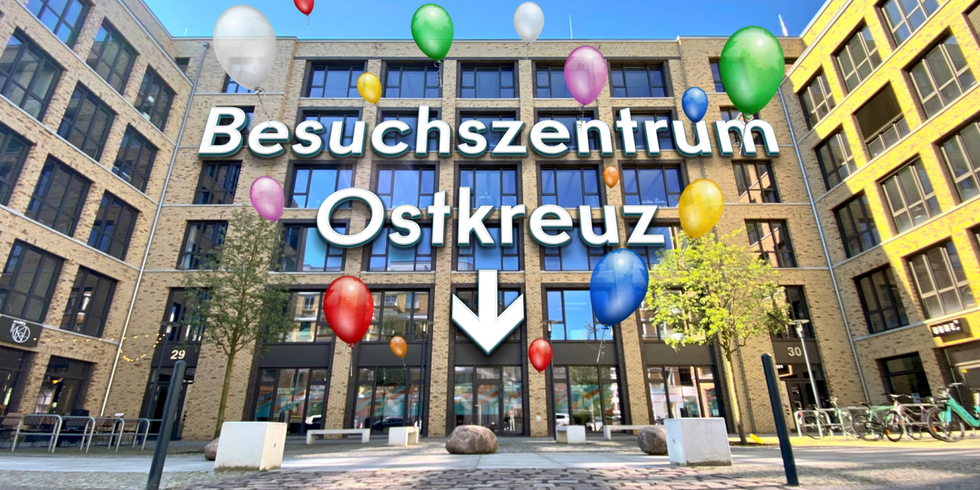 Außenanscht des neuen Besuchszentrums Ostkreuz der Berliner Landeszentrale für politische Bildung - 6stöckiges Gebäude mit Glasfenster-Fassade und einmontiertem Schriftzug "Besuchszentrum Ostkreuz" und aufsteigende bunte Ballons