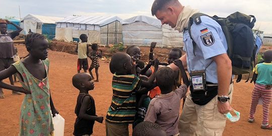 Polizeibeamter mit Kindern in einem Lager in Afrika