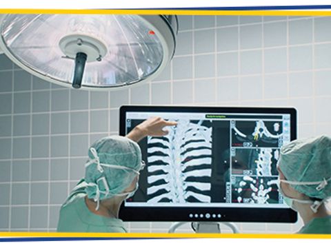 Zwei Chirurgen schauen auf digital erstelltes "Röntgenbild"