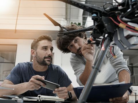 Two young men building a drone