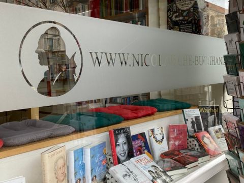 Logo der Nicolaischen Buchhandlung am Fenster, darunter Bücher