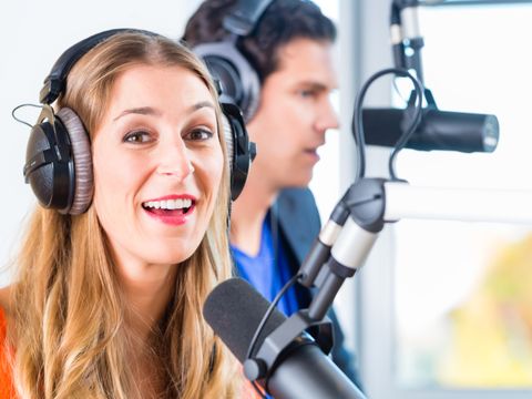 Frau und Mann mit Kopfhörern bei Studioaufnahme, Podcast