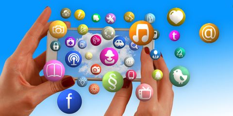 Hand mit Smartphone und Social-Media-Symbolen