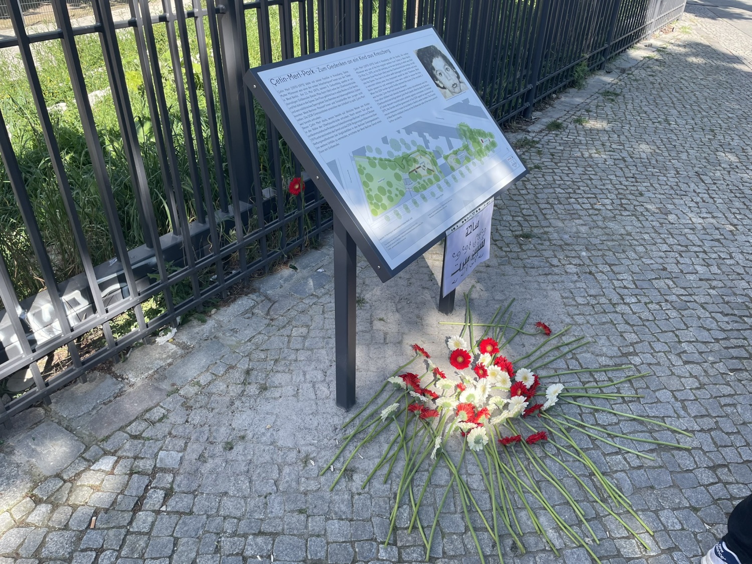 Gedenktafel für Cetin Mert mit niedergelegten Blumen