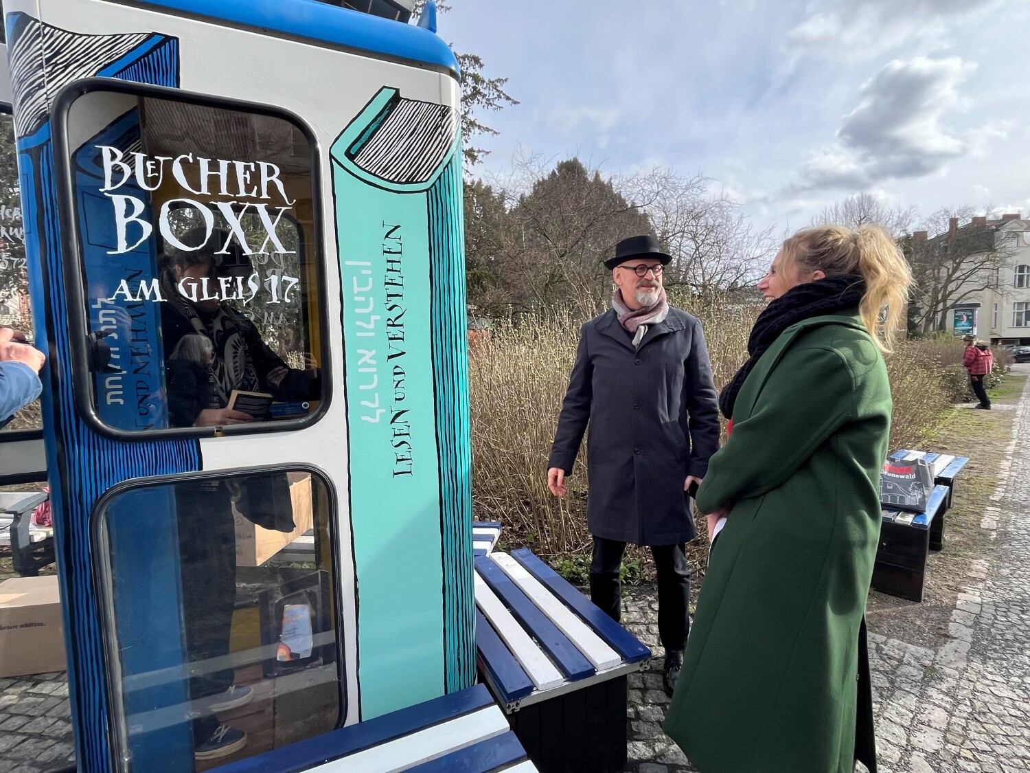 neue Bücherbox am Bahnhof Grunewald/Gleis17 - kIrstin Bauch schaut sich die neue Box aus der Nähe an