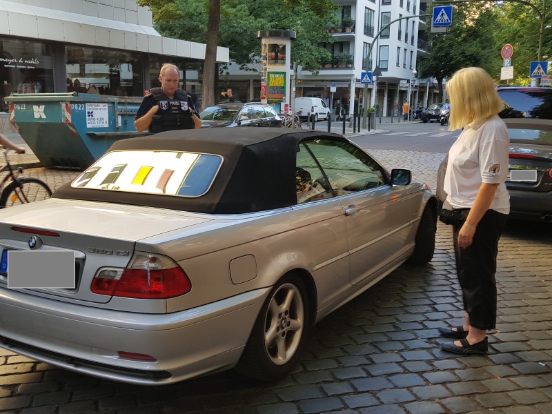 Andreas Tschisch und eine Mitarbeiterin des Ordnungsamts ermahnen einen Autofahrer nicht in zweiter Reihe zu parken.