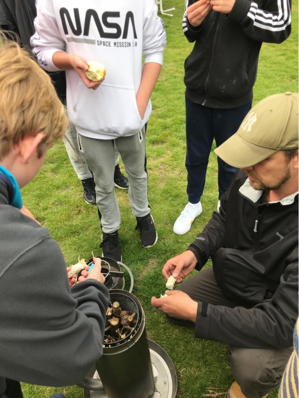 Befüllen des Pyrolyse-Ofens mit Holzstöcken, Umweltbildungsgruppe von Carsten Knobloch von der Koordinierungsstelle Umweltbildung in Charlottenburg-Wilmersdorf