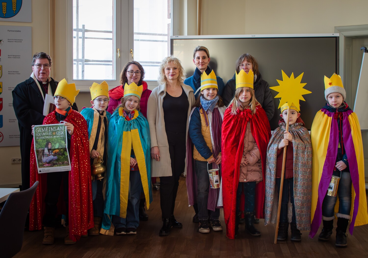 Gruppenbild mit den Sternsingern, dem Pfarrer, den Lehrerinnen und der Bezirksstadträtin Frau Dr. Catrin Gocksch