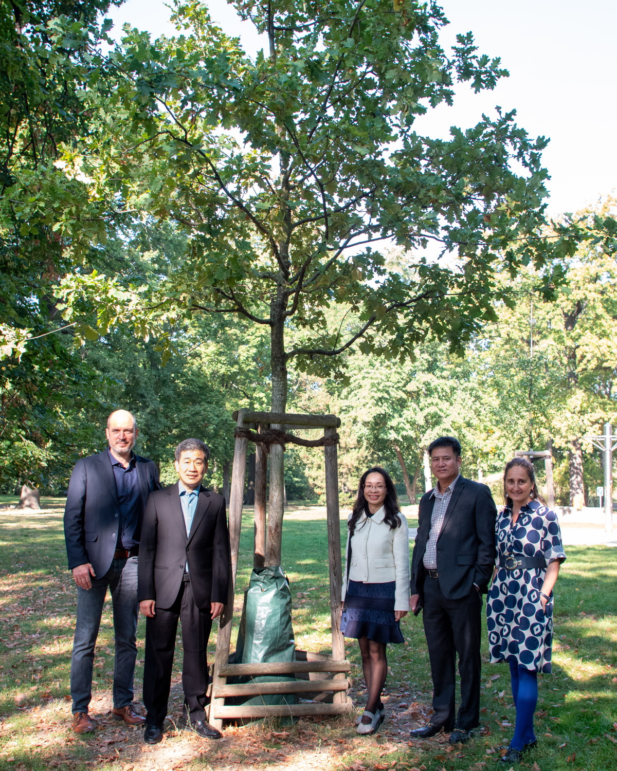 von links nach rechts: Conrad Masius, Amtsleiter des Umwelt- und Naturschutzamtes; Quôc Hoàn Nguyen, Lai Thi Thu Hà, Polizeichef Hà Manh Hùng und Julia Koehler bei der Besichtigung des Partnerschaftsbaums im Stadtpark Lichtenberg.