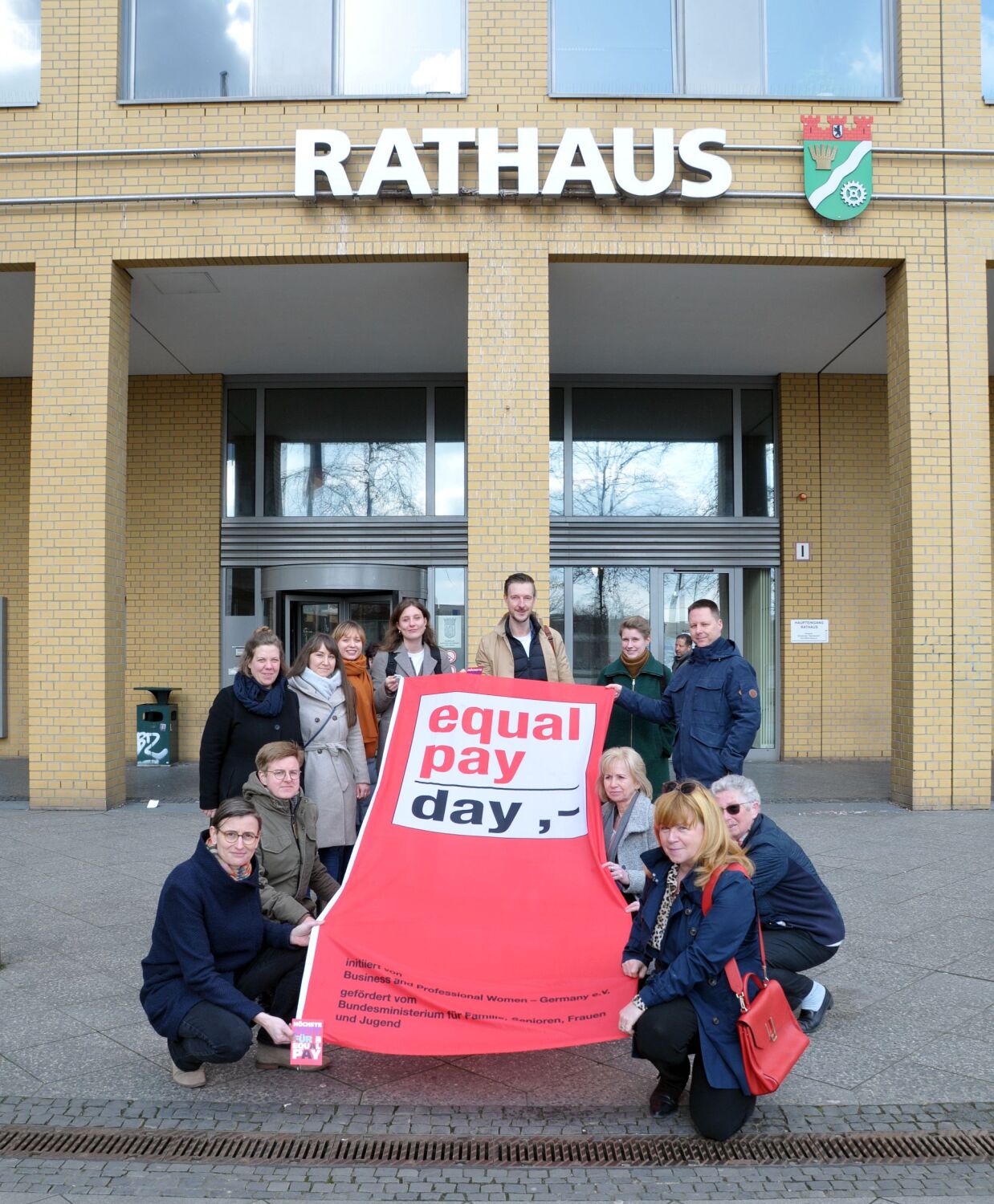 Fahnenhissung zum "Equal Pay Day 2024" - Juliane Witt, Heike Wessoly, Gordon Lemm, Stefan Bley und die Beauftragten Maja Loeffler und Vanessa Krah halten die Fahne