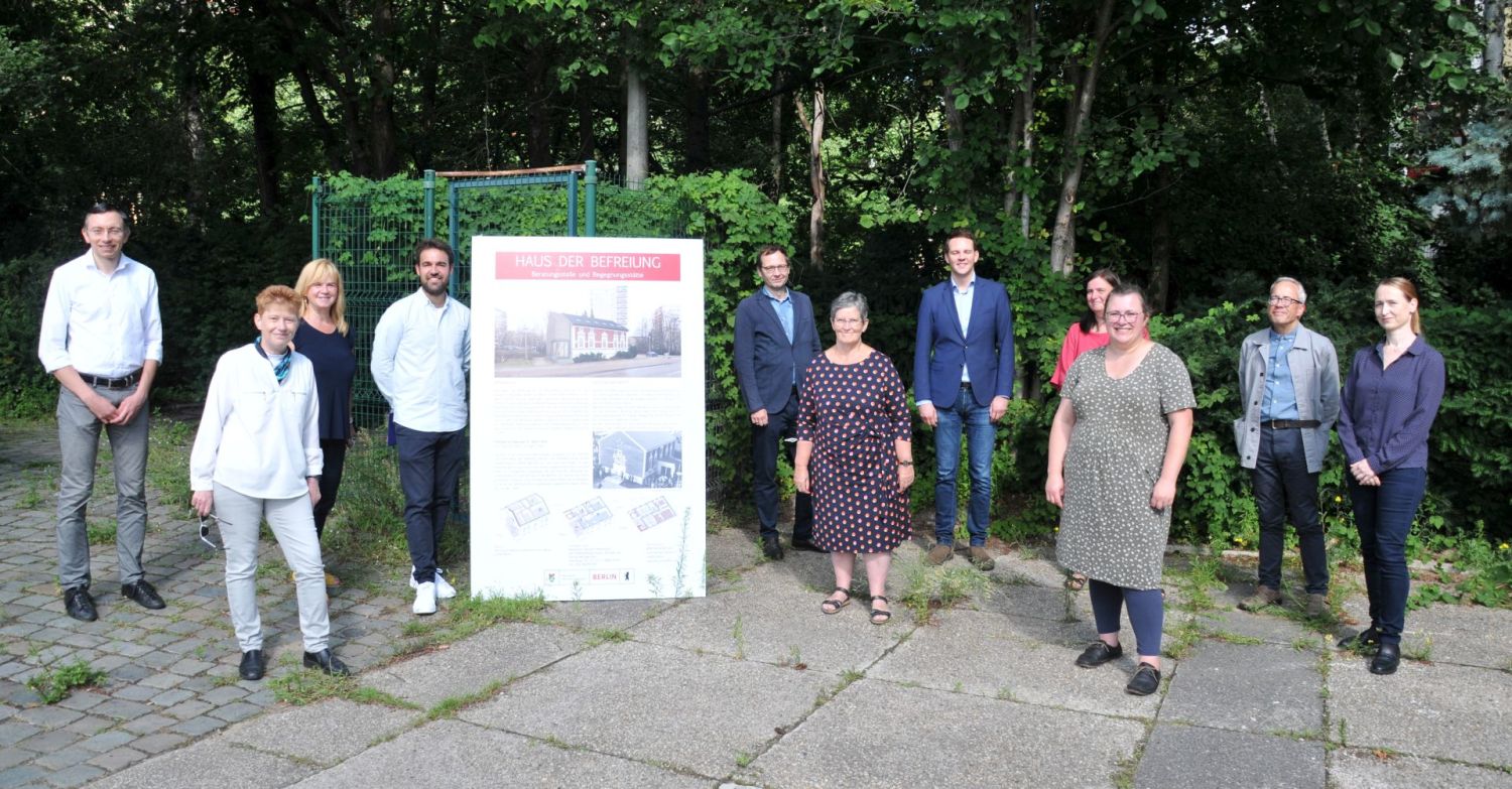 Haus der Befreiung - Gruppenbild mit der Tafel zur Geschichte und zum Umbau