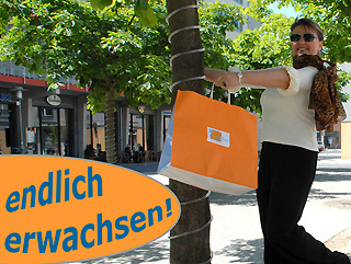 Frau unter einem Baum mit einer orangenen Tüte in der Hand