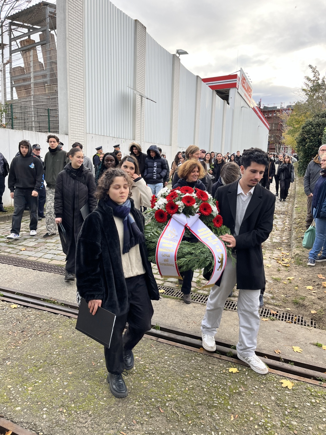 Schüler*innen der Theodor-Heuss-Gemeinschaftsschule tragen den Kranz zum Gedenkort Güterbahnhof Moabit.