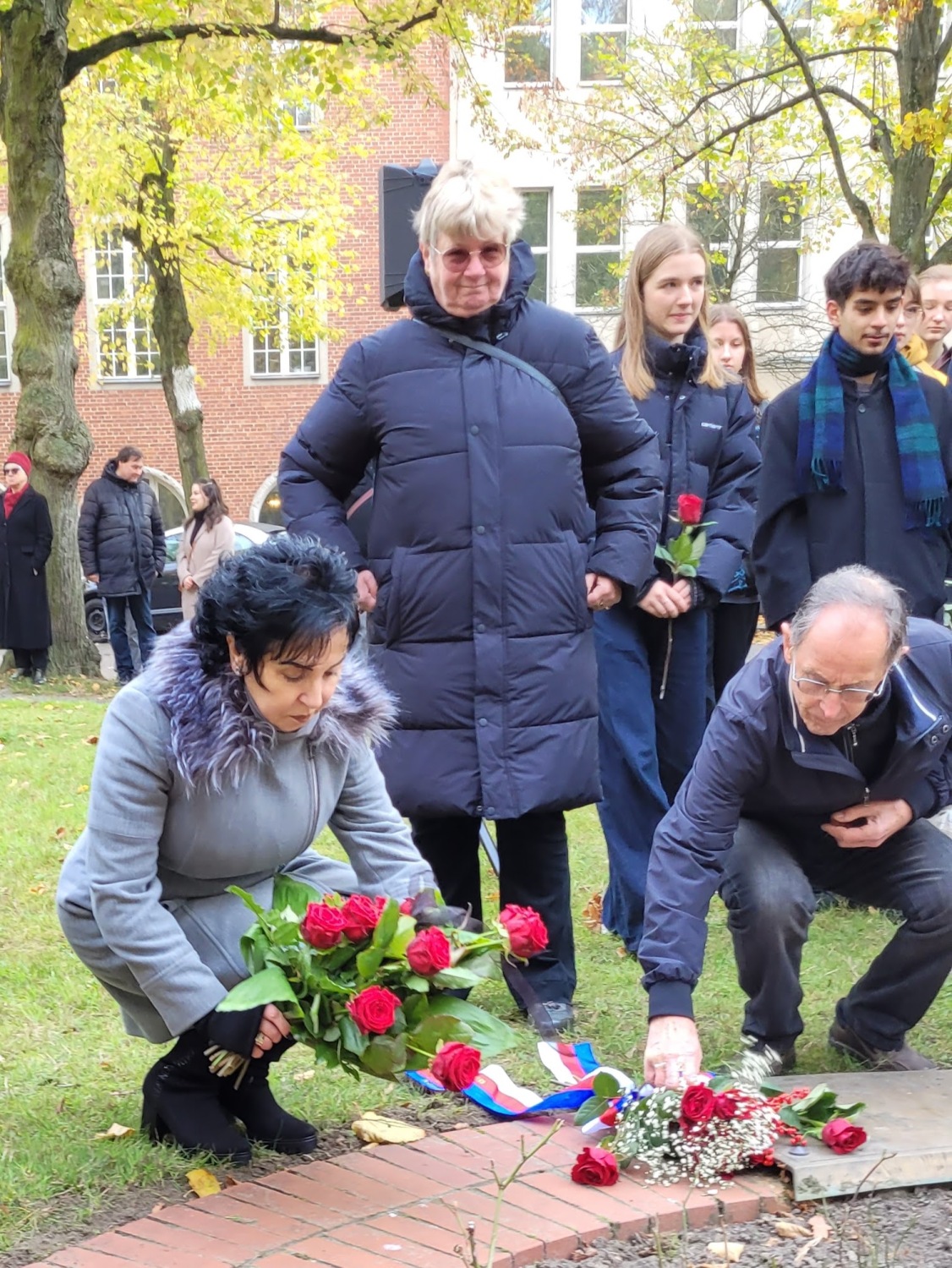 Bürgermeisterin Demirbüken-Wegner legt mit Reincikendorfer Bürgern Rosen am Beet für die Opfer von Lidice nieder.