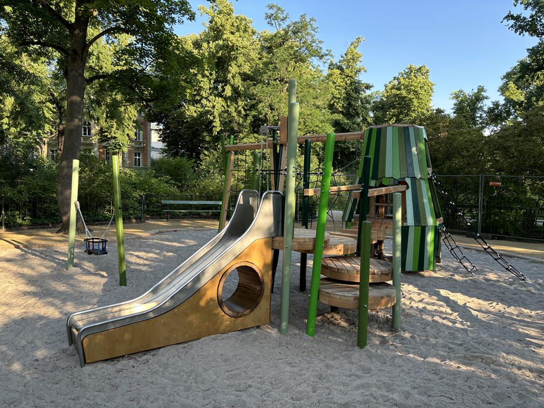 Kleinkindschaukel und Spielgerät mit Rutsche auf dem Spielplatz am Augustaplatz