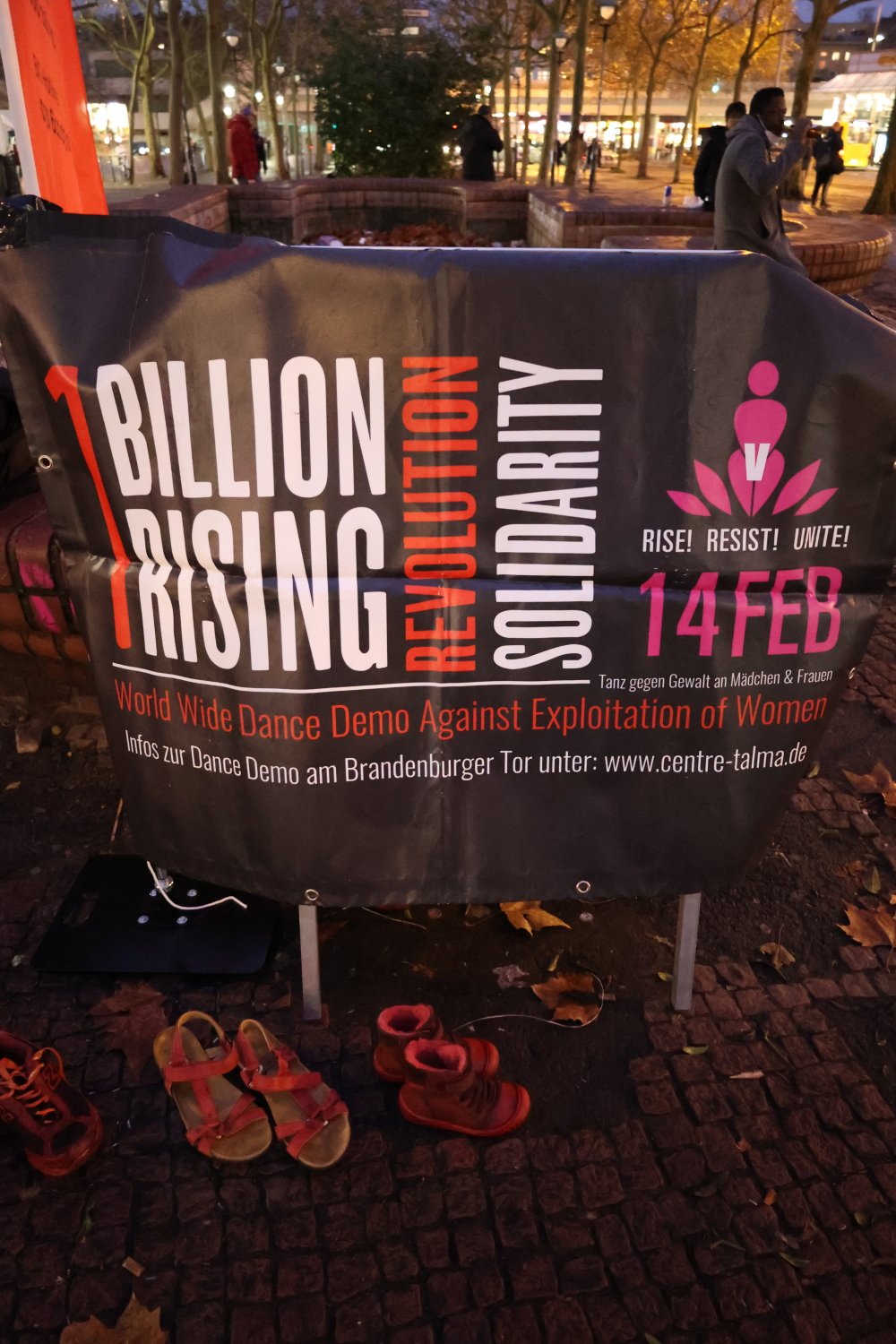 Rote Schuhe vor dem Banner "1 Billion Rising Revolution 2022 Solidarity", einer internationalen Veranstaltung am 14.02.2022 - Tanz gegen Gewalt an Mädchen und Frauen