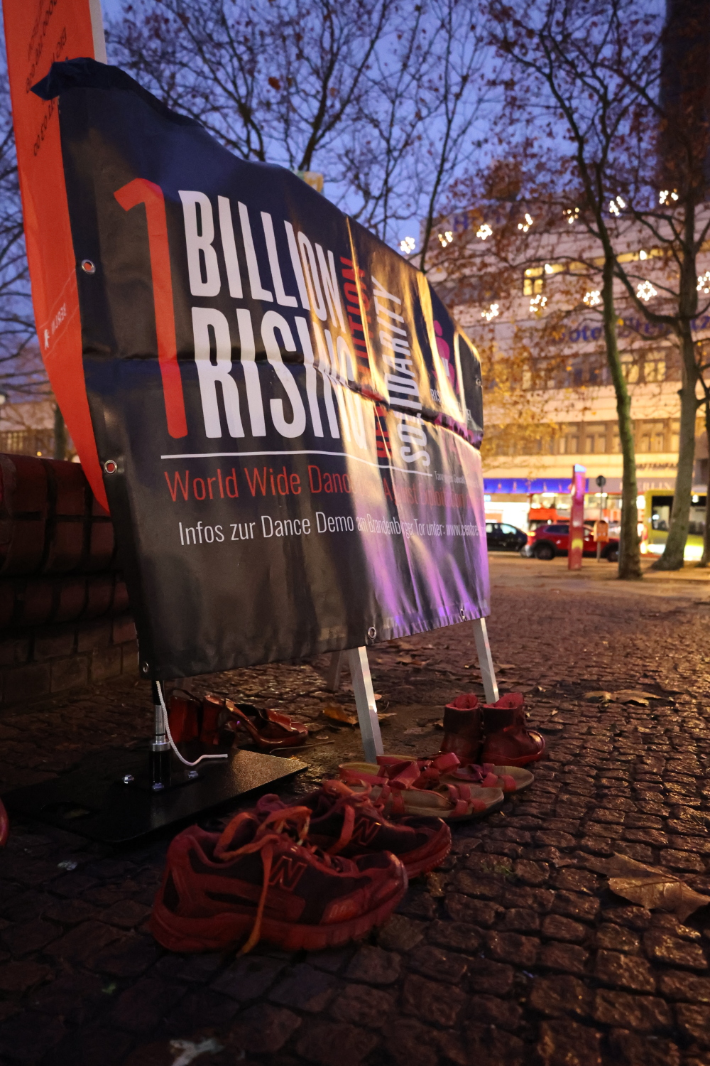 Rote Schuhe vor dem Banner "1 Billion Rising Revolution 2022 Solidarity", einer internationalen Veranstaltung am 14.02.2022 - Tanz gegen Gewalt an Mädchen und Frauen