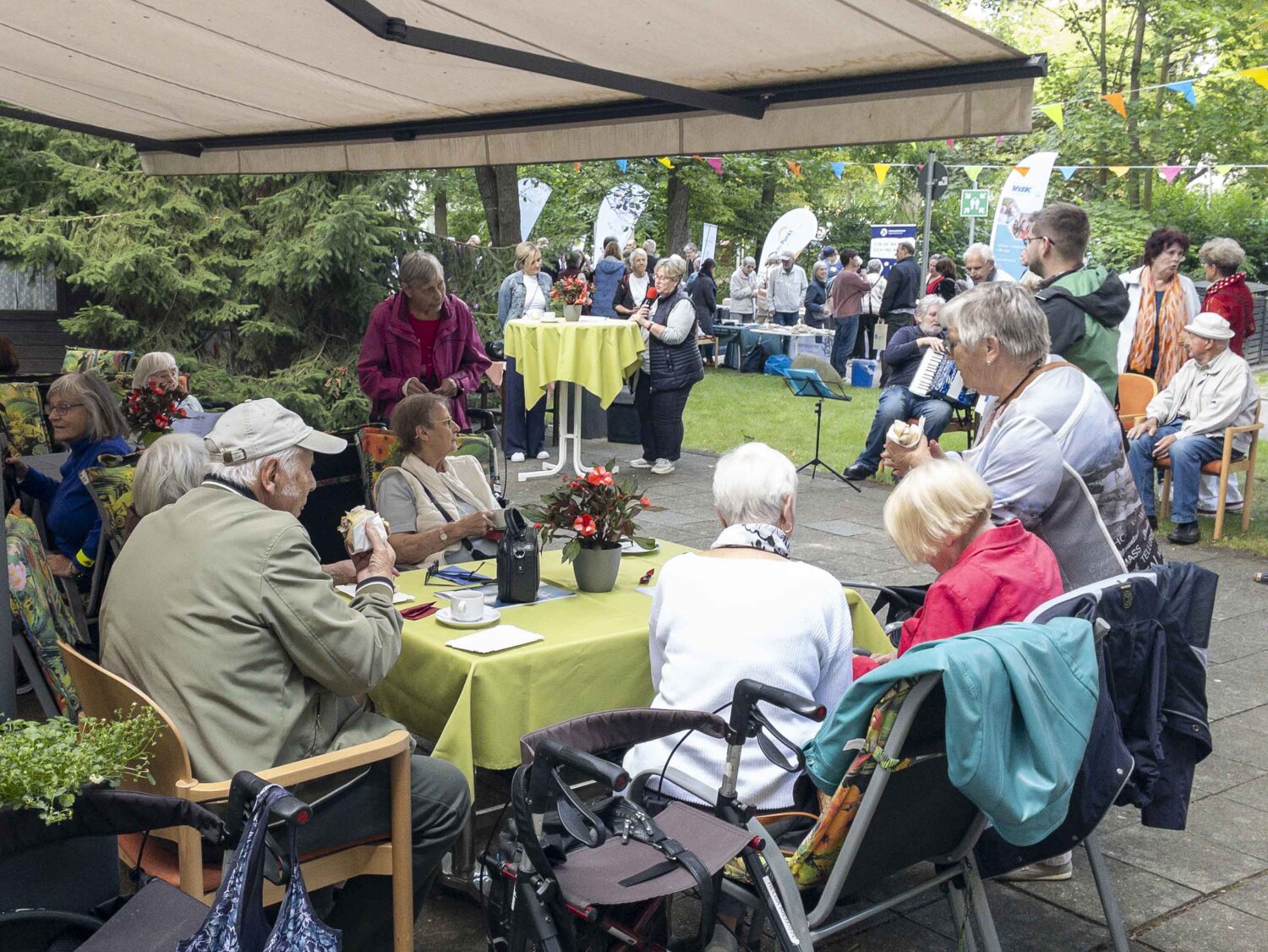 Gruppe von Besucherinnen und Besuchern der Seniorenmesse im Garten des Kommunikationszentrums am Ostpreußendamm