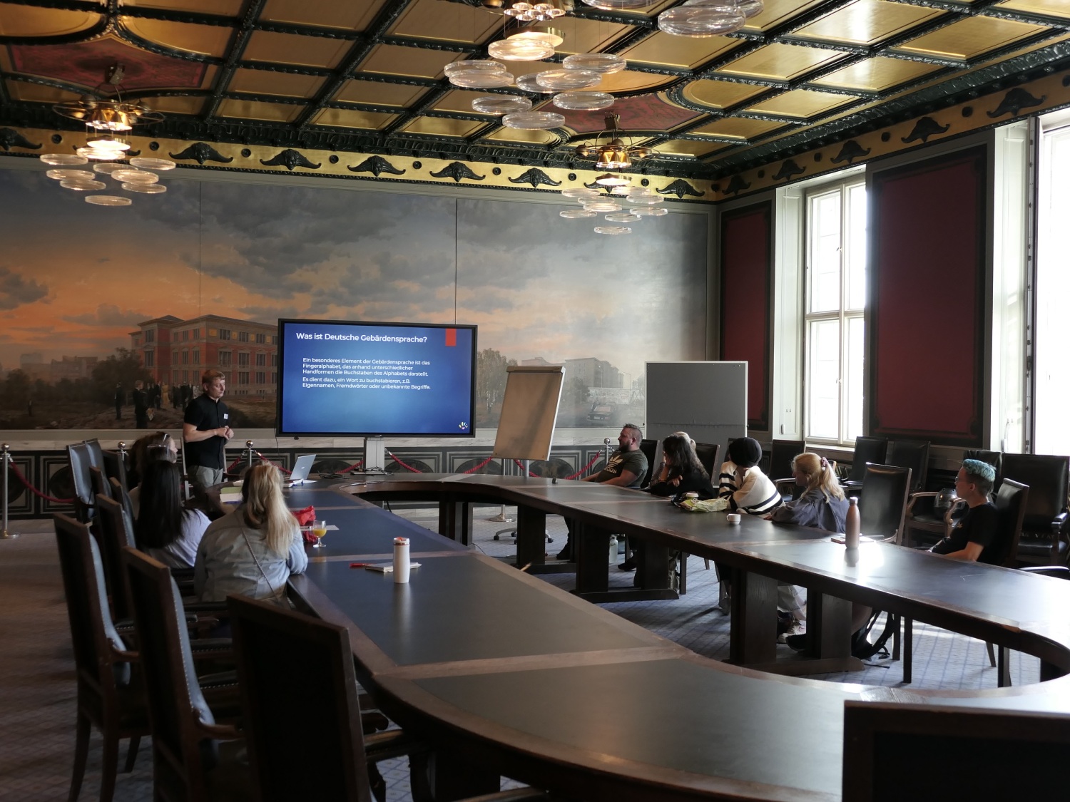 In einem Saal wird ein Vortrag zum Thema Deutsche Gebärdensprache gehalten.