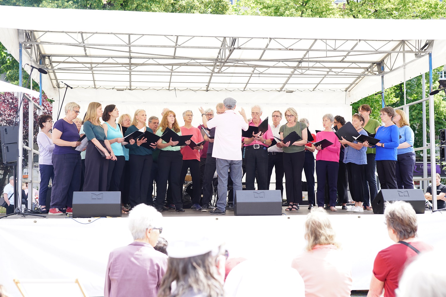 viele singende Menschen auf einer Open-Air-Bühne