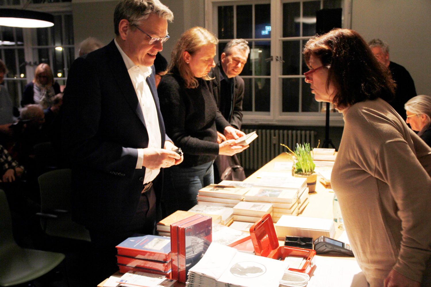 zwei Menschen unterhalten sich an einem Tisch mit Büchern