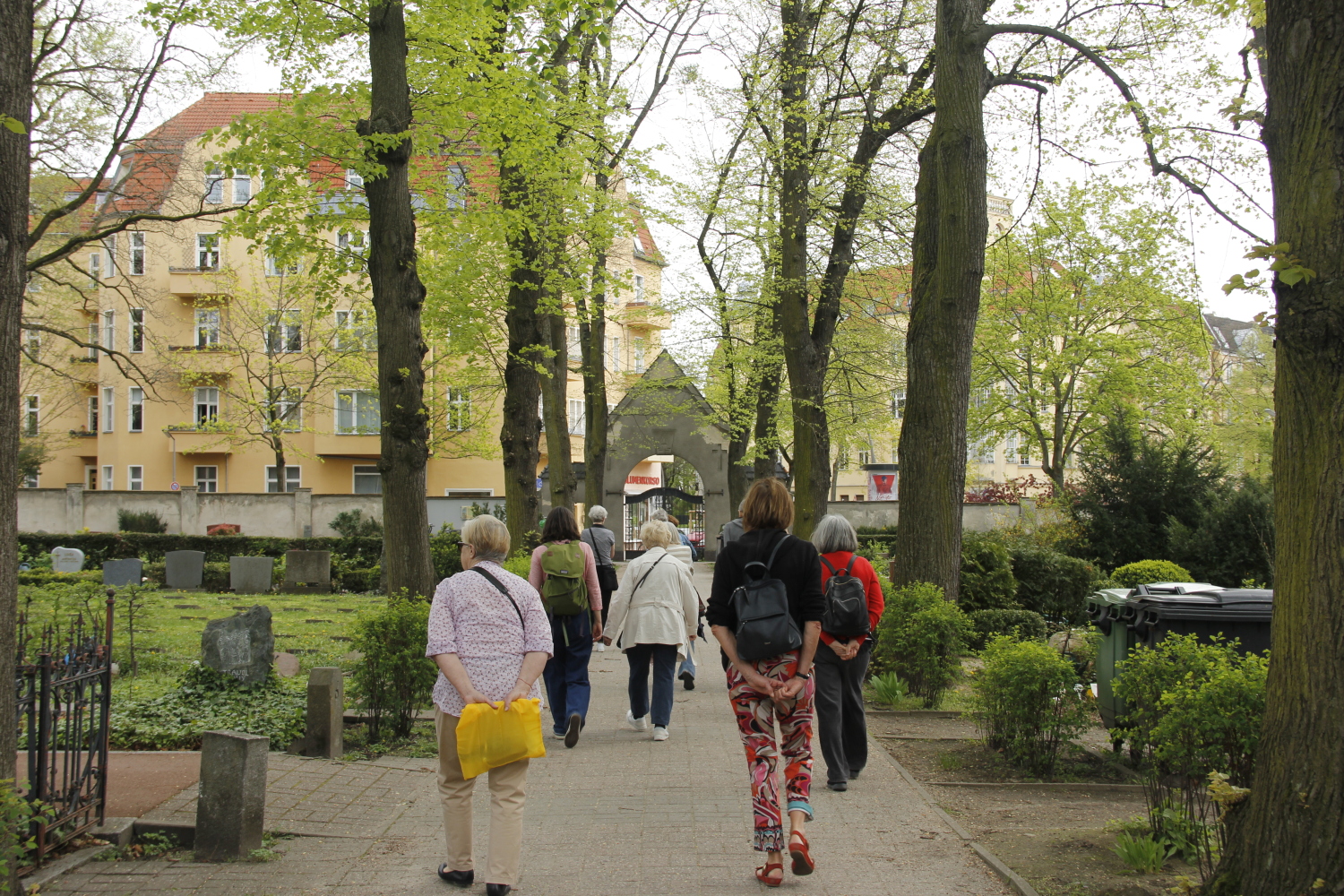 Menschen von hinten auf einem Friedhof