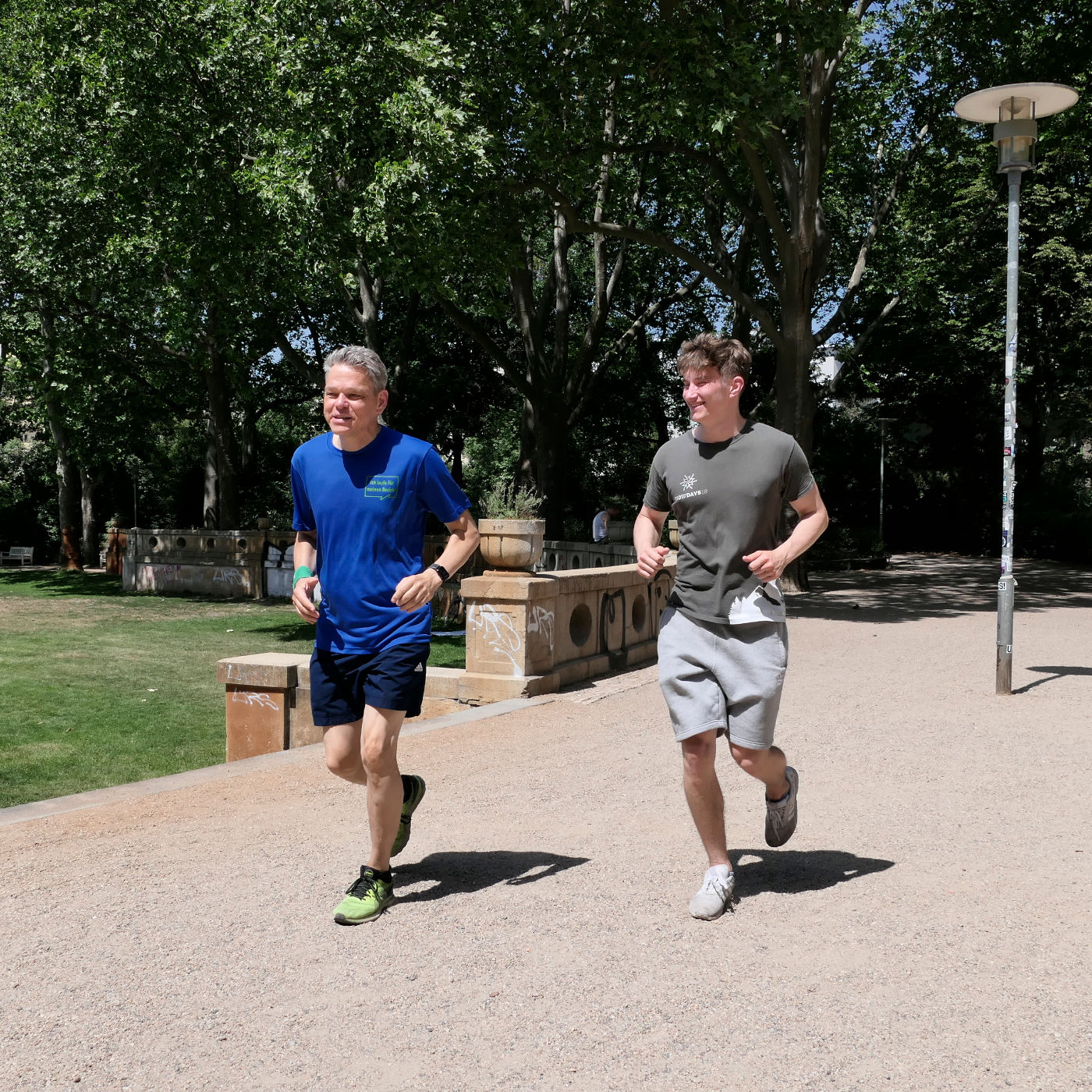 zwei Männer joggen durch einen Park