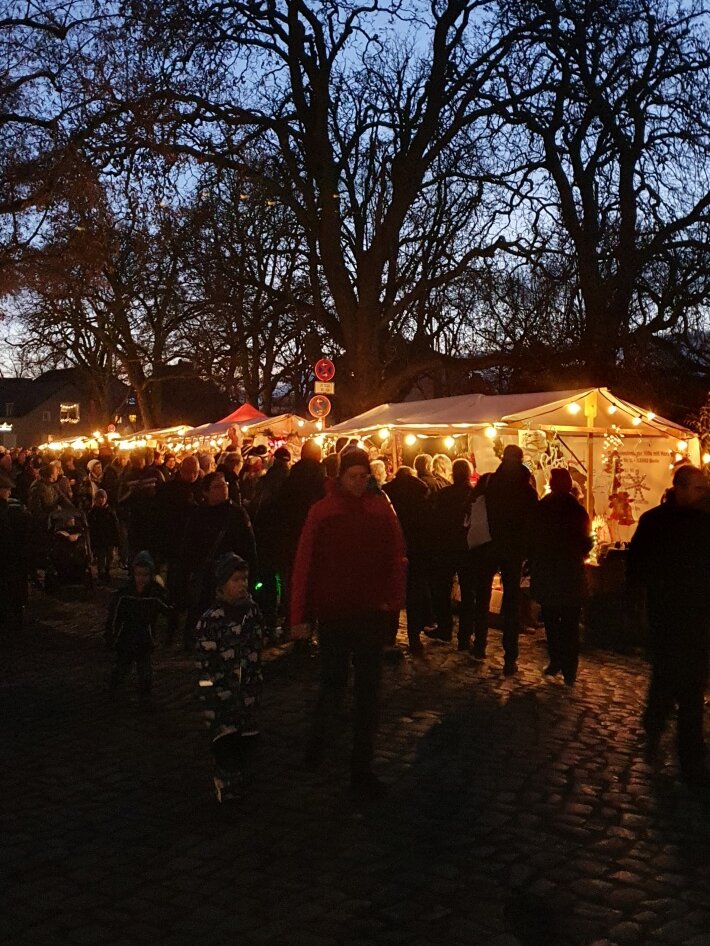 Stände mit Lichterketten bei Nacht