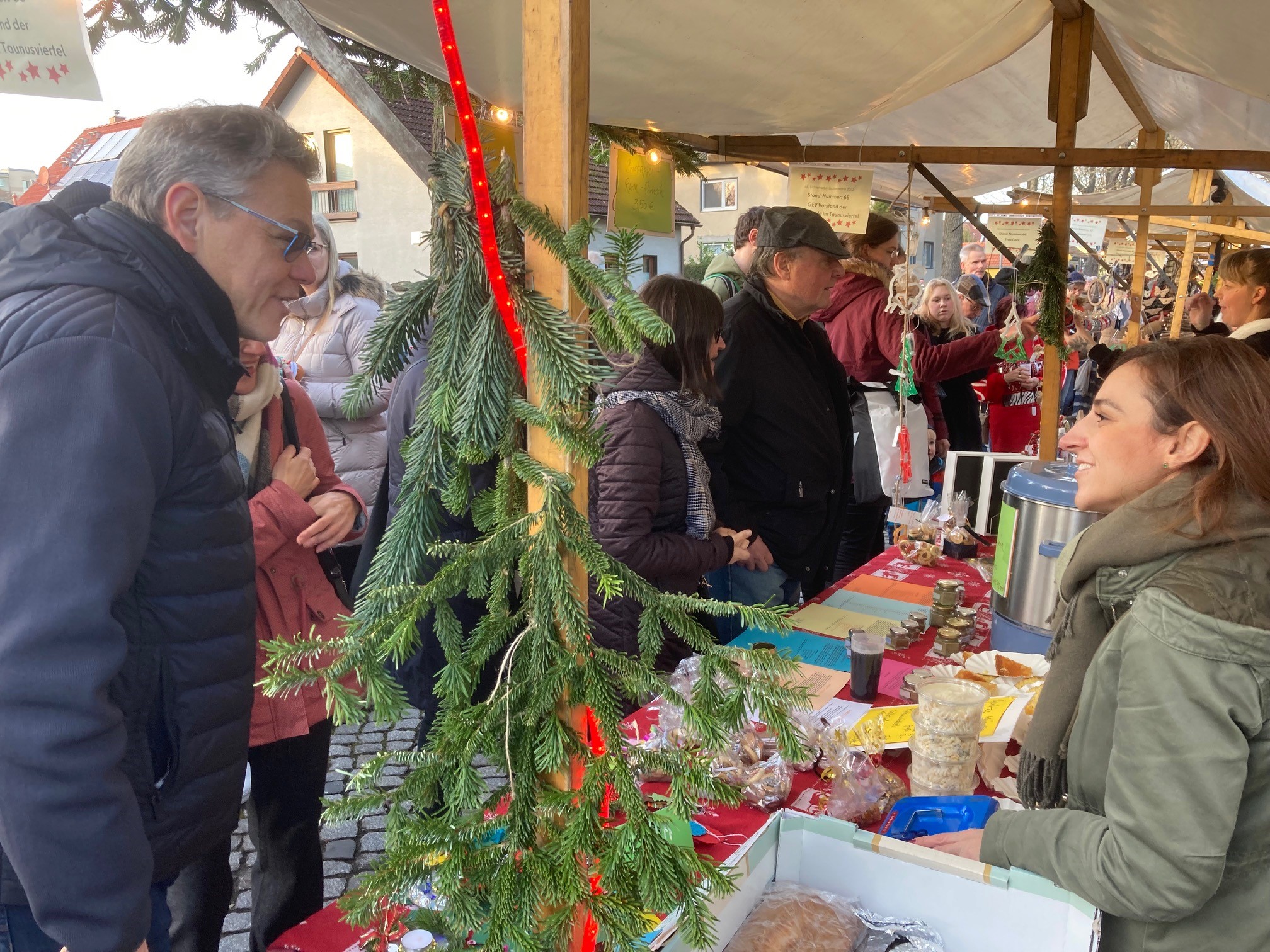 Mann spricht mit Frau am Markstand