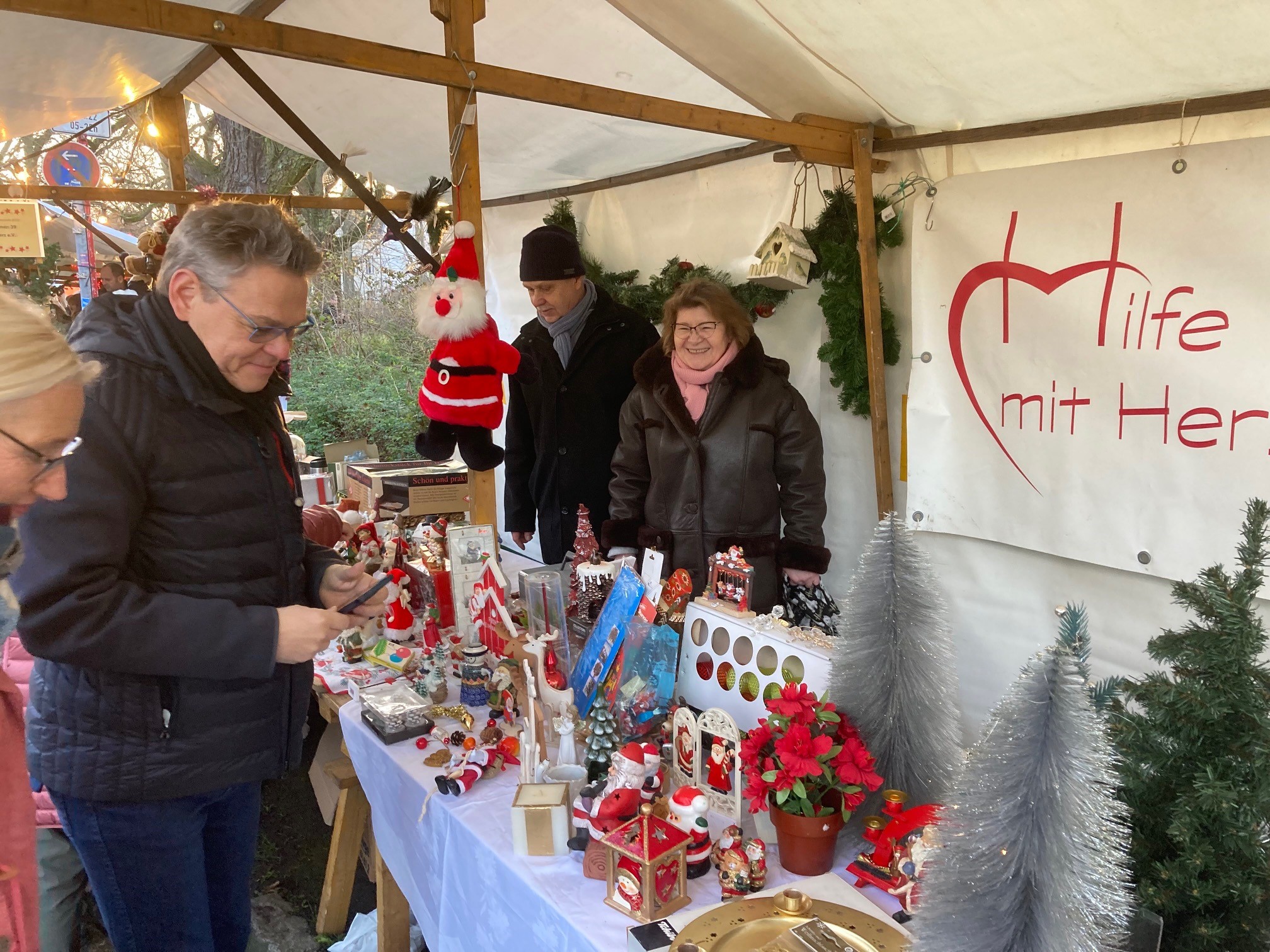 Frau und Mann freundlich an einem Stand mit Weihnachtsdeko 