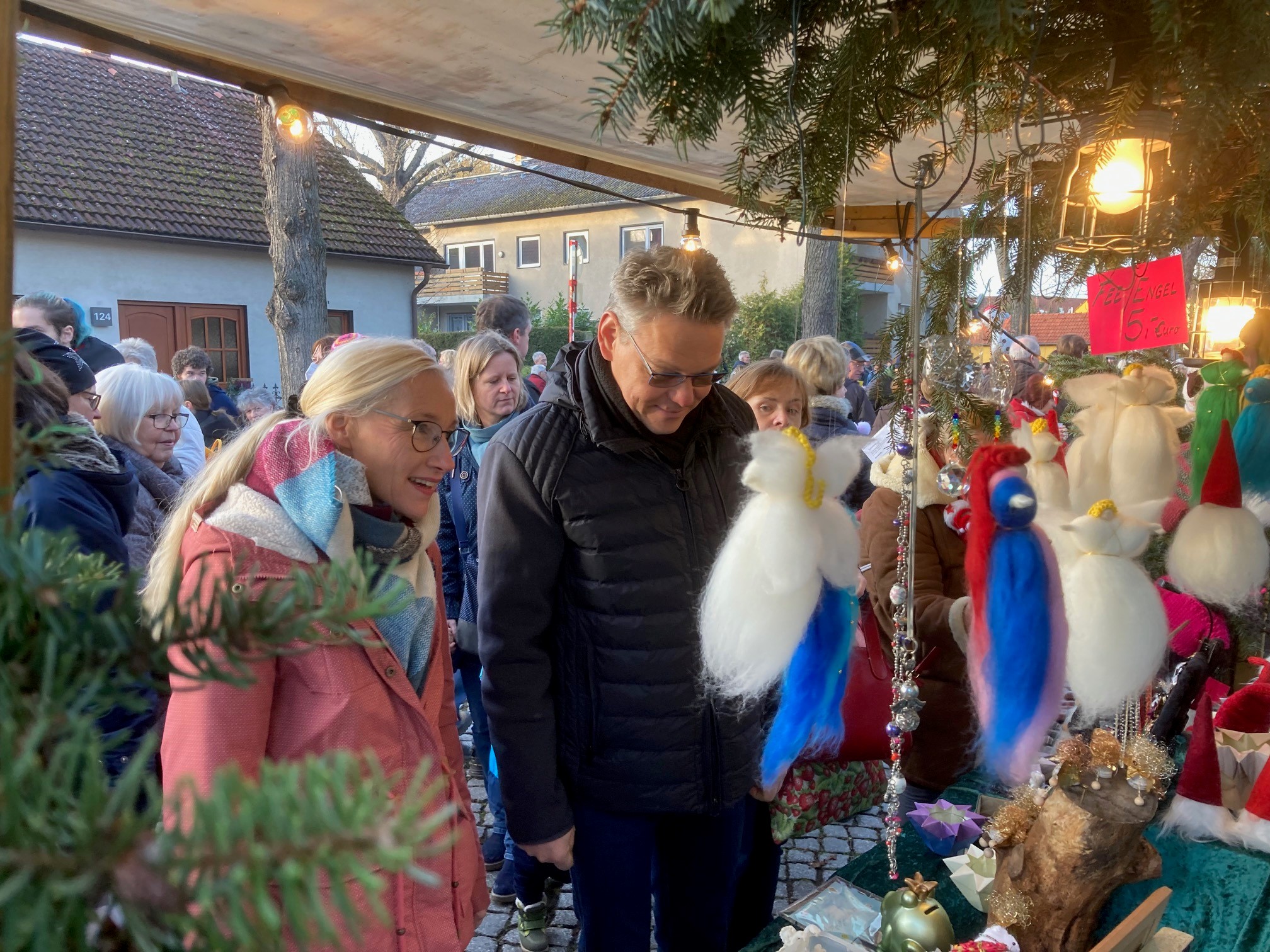 Frau und Mann an einem Marktstand auf einem Weihnachtsmarkt 