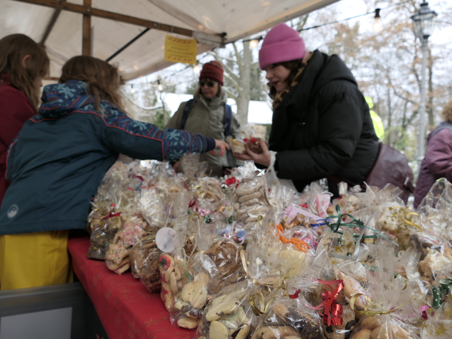 3 Menschen an einem Stand und ganz viele Plätzchen