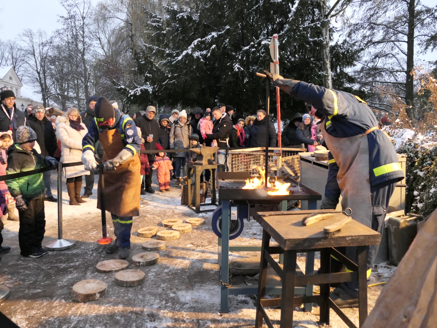 zwei Männer brennen Motive in Holzscheiben