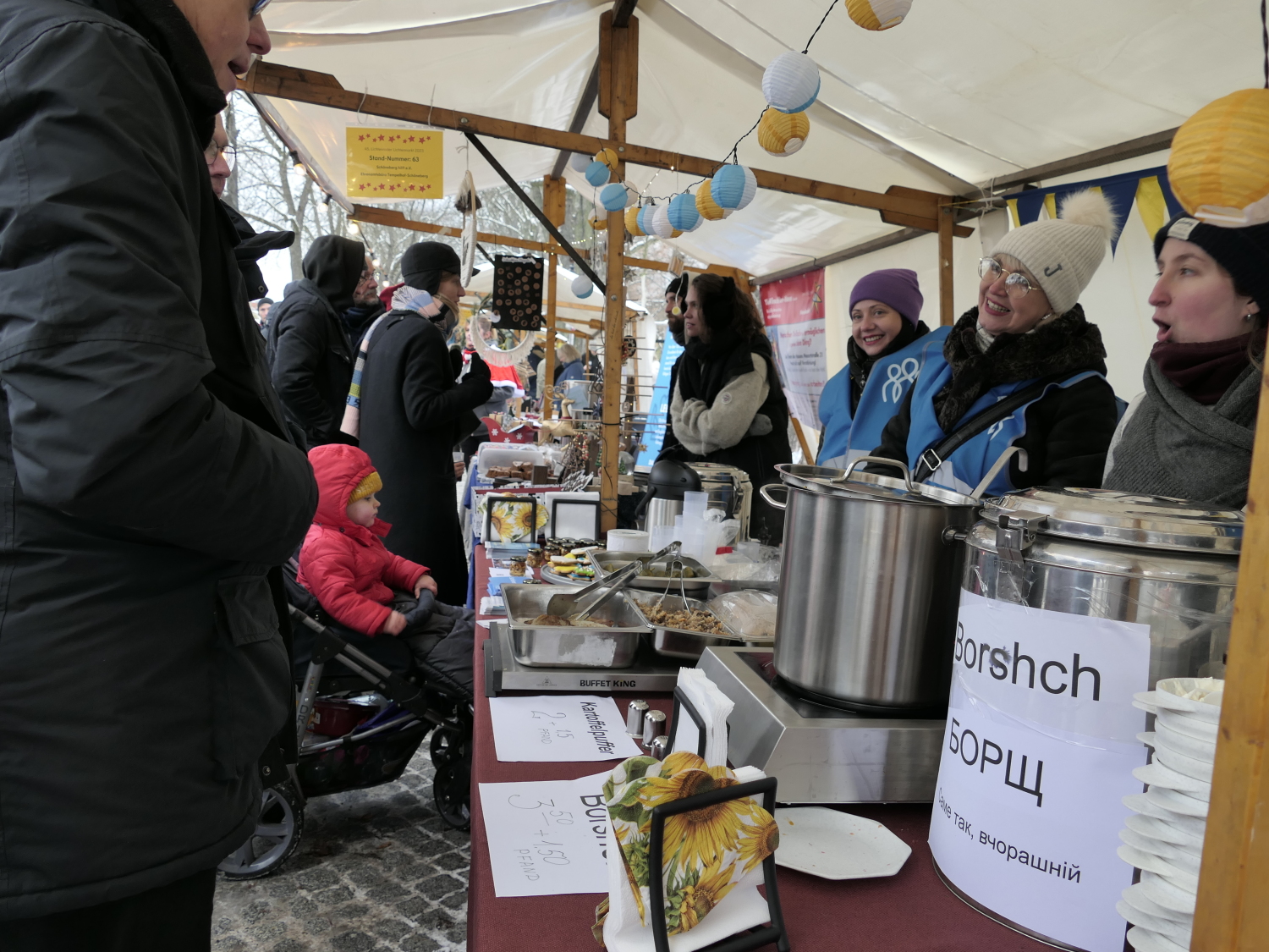 Menschen stehen an einem Stand und verkaufen Borshch