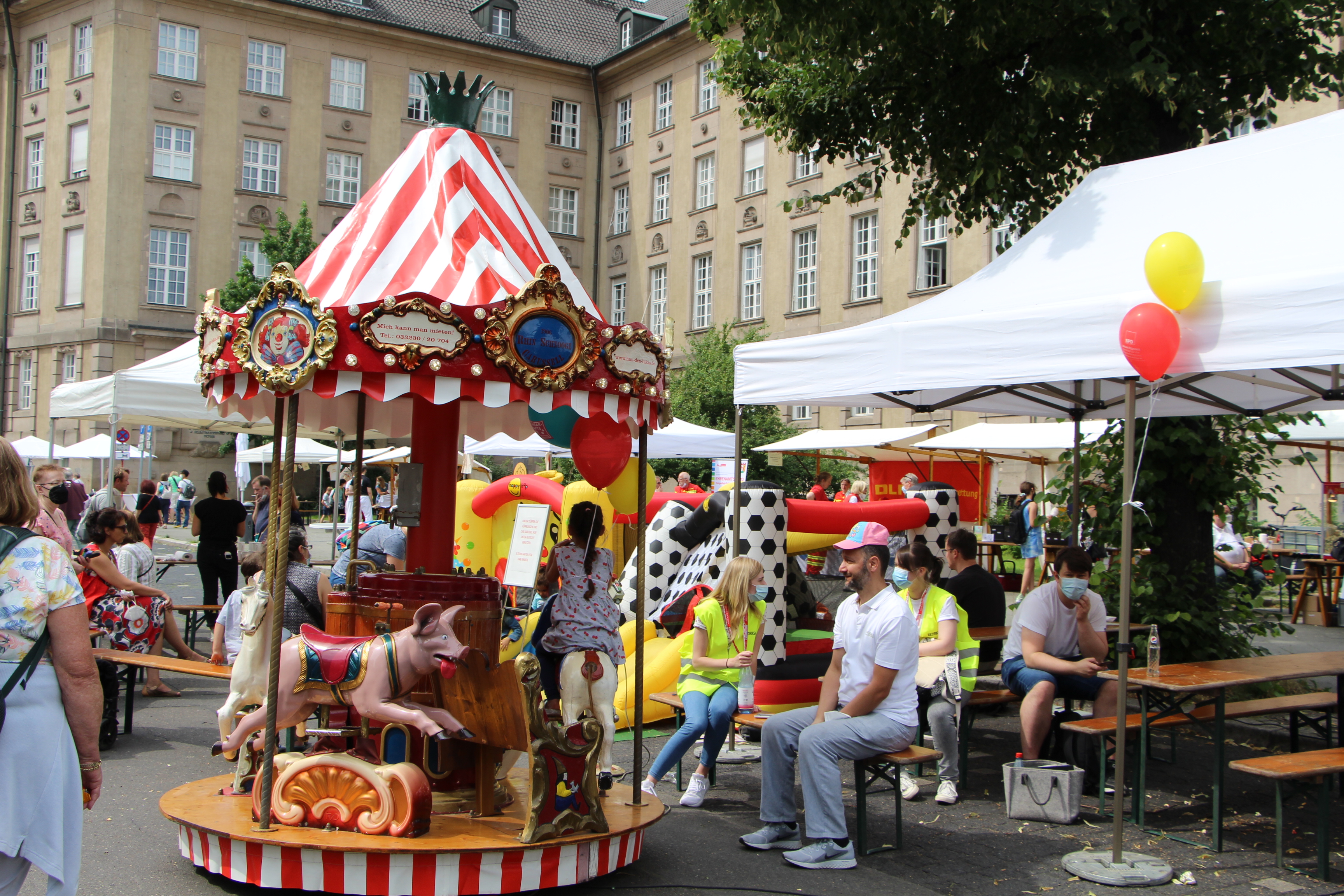 Buntes Karussel mit spielenden auf dem Nachbarschaftsfest