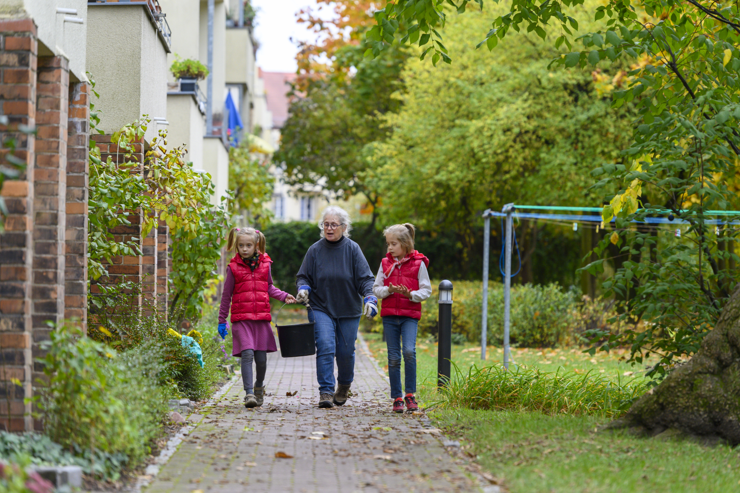 Projektumsetzung degewo - Ältere Dame macht mit Kindern Gartenarbeit 