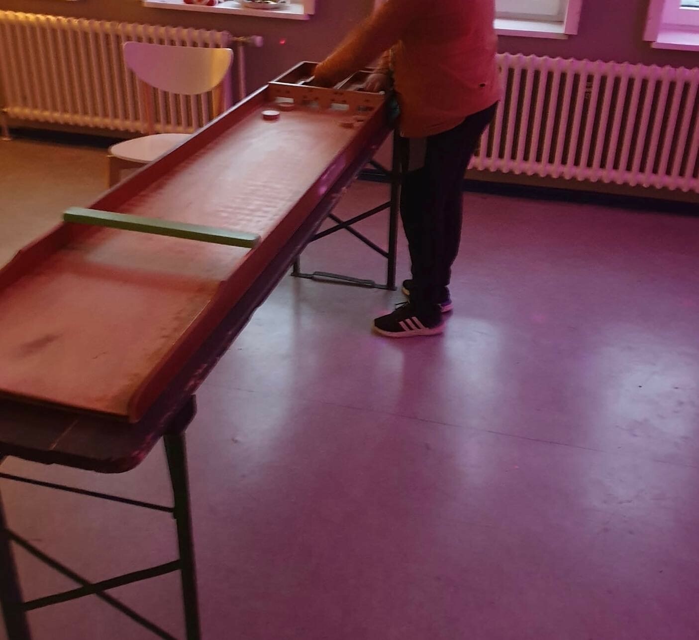 Ein Jugendlicher spielt mit dem Shuffleboard