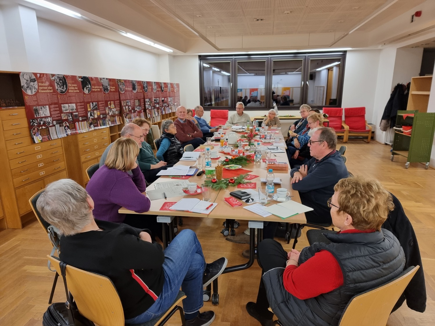 Literaturinteressierte Menschen sitzen um einen großen Tisch