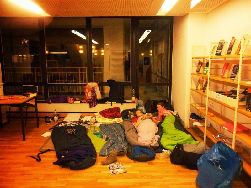 Zwei Mädchen liegen in ihren Schlafsäcken auf dem Boden der Bibliothek