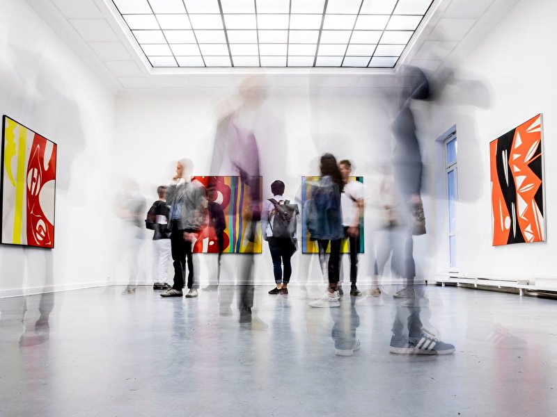 Besucher schauen eine Ausstellung in einer Galerie an